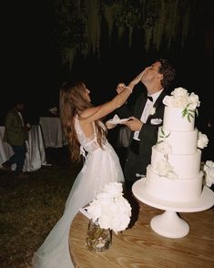 a bride and groom are feeding each other cake at their wedding reception in the evening