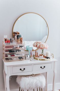 a white vanity with drawers and a mirror on the wall next to it is filled with makeup