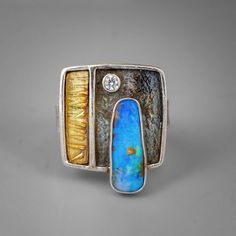 Gold & Silver Ring - A stunning turquoise-hued boulder opal paired with a 3mm white topaz lights up this striking gold and silver statement ring. Highly textured with a dark patina that shows up the lovely gem stones, this lovely one-of-a-ring is a size 8. Metal Clay Rings, Gold Stone Ring, Boulder Opal Jewelry, Rings With Stones, Silver Stone Ring, Modern Rings, Boulder Opal Ring, Polymer Clay Ring, Unique Silver Rings