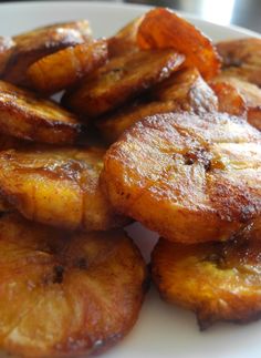 some bananas are on a white plate and have been fried with sugary brown sauce