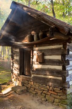 an old log cabin with pots and pans on the roof is in the woods