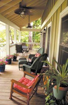 a porch with chairs and potted plants on it