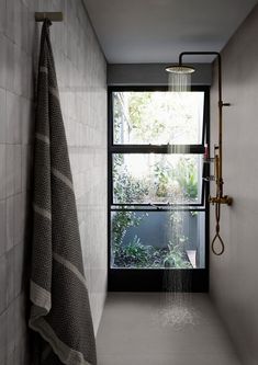 a bathroom with a shower head next to a window