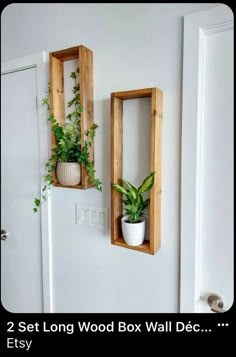 two wooden boxes with plants in them on the wall