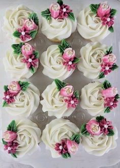 cupcakes with white frosting and pink flowers