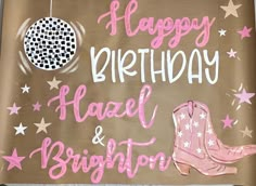 a happy birthday sign with pink boots and stars