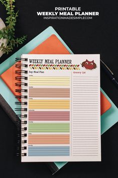 the weekly meal planner with an owl sticker is on top of two notebooks