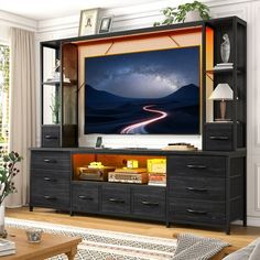 a living room with a large flat screen tv on top of a wooden entertainment center