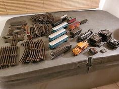 an old suitcase filled with lots of different types of train tracks and trains on it