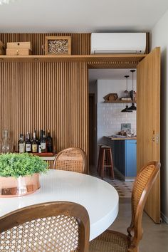 a dining room table with chairs and a potted plant on top of the table