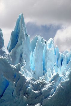 an iceberg is shown in front of some clouds