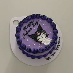 a purple birthday cake decorated with an image of a witch