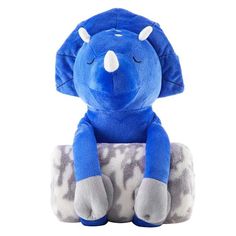 a blue elephant sitting on top of a pillow