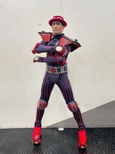 a statue of a man dressed in red and blue with his hands on his hips