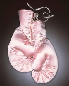 two pink satin gloves with white laces on the top and one in the middle