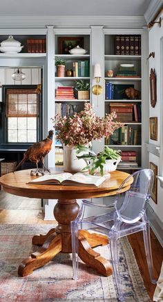 a table and chairs in a room with bookshelves