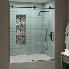 a bathroom with a glass shower door and tiled walls, along with a towel rack on the wall