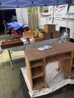 a table is being constructed in front of a camper with boxes on the ground