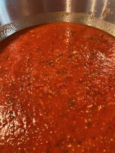 a large pot filled with red sauce on top of a stove