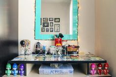 a vanity with various items on it in front of a mirror and some lights behind it