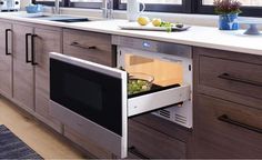 an open oven door in a kitchen next to a counter with fruit and vegetables on it