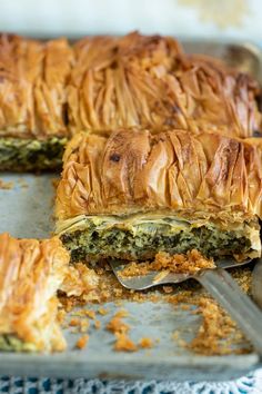 a close up of a pastry on a pan with a knife and fork next to it