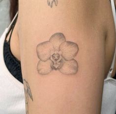 a woman with a tattoo on her arm has a flower tattooed on it's side