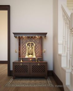 a golden statue sitting on top of a wooden chest in a room next to stairs