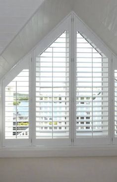 an open window with white shutters in a room