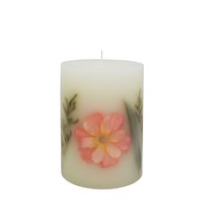 a white candle with pink flowers on it