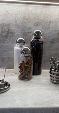 there are many items on the counter in this bathroom set up with toothbrushes and soap dispensers