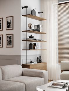 a living room filled with white furniture and pictures on the wall above it's bookshelf