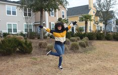 a woman jumping in the air with her arms outstretched