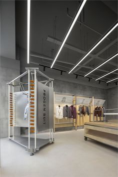 the inside of a clothing store with clothes on racks