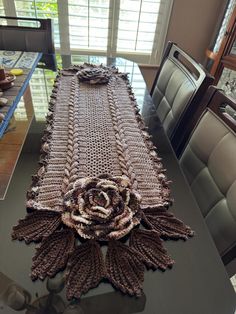 the table is covered with crochet and has a large flower on it's center