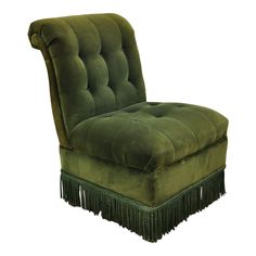 a green chair with tassels on the legs and foot rests against a white background