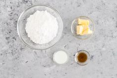 ingredients to make cheesecake sitting in bowls on a counter top with milk and butter