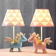 two little lamps that look like unicorns are next to each other on a table