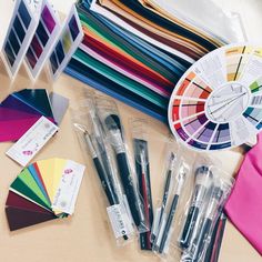 there are many different color samples and pens on the table next to eachother