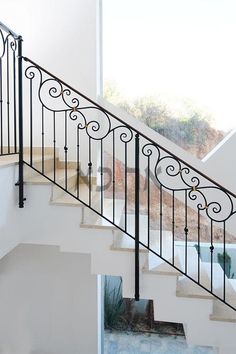 a stair case with wrought iron railing and handrail