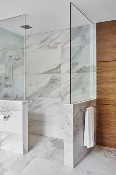 a bathroom with marble walls and flooring next to a walk - in shower stall