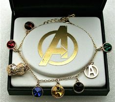 the avengers bracelet is in its box and it has various charms on one side, including an