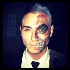 a man with his face painted like a clown is posing for the camera in a dark room