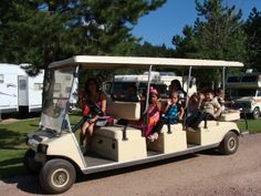 a group of people riding on the back of a golf cart