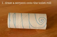 a roll of toilet paper sitting on top of a wooden table with the words i draw a serpent onto the toilet roll