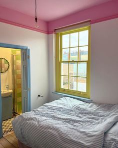 a bed sitting under a window in a bedroom