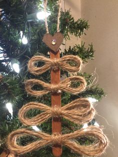 a christmas tree made out of wood and rope with a heart hanging from the top