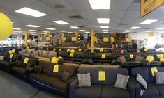 a large room with couches and yellow tags on the back of each sofas