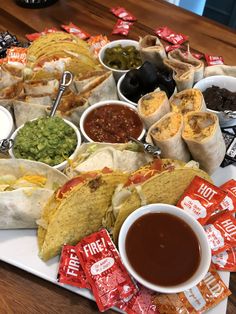 mexican food is laid out on a tray with chips, salsa and guacamole