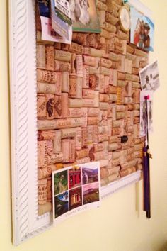 a cork bulletin board with pictures and other items on it's back drop off the wall